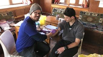 Eric takes blood from one of the research participants